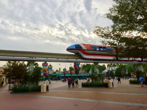 Disneyland Monorail glides across the esplanade at Disneyland Resort, with California Adventure entrance in the background.